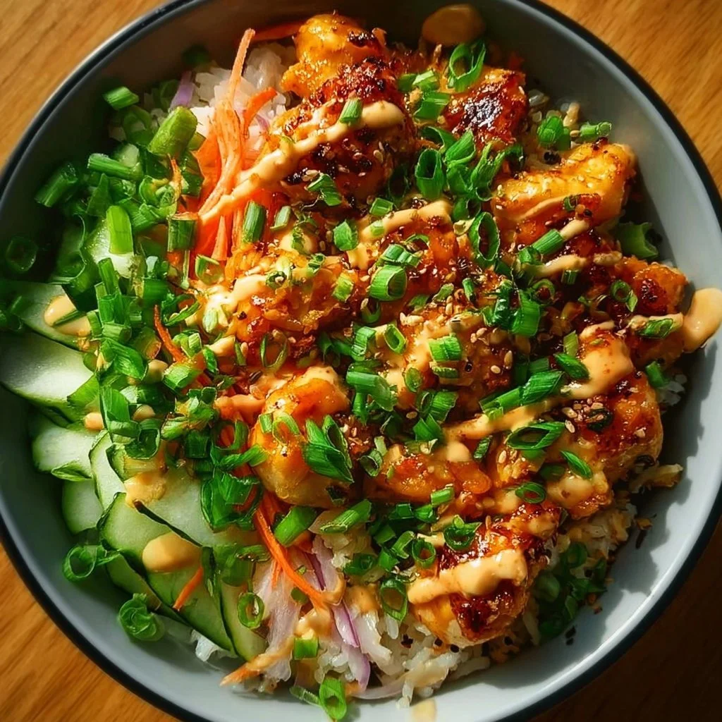 Bang Bang Chicken Bowl garnished with vegetables and drizzled with sauce