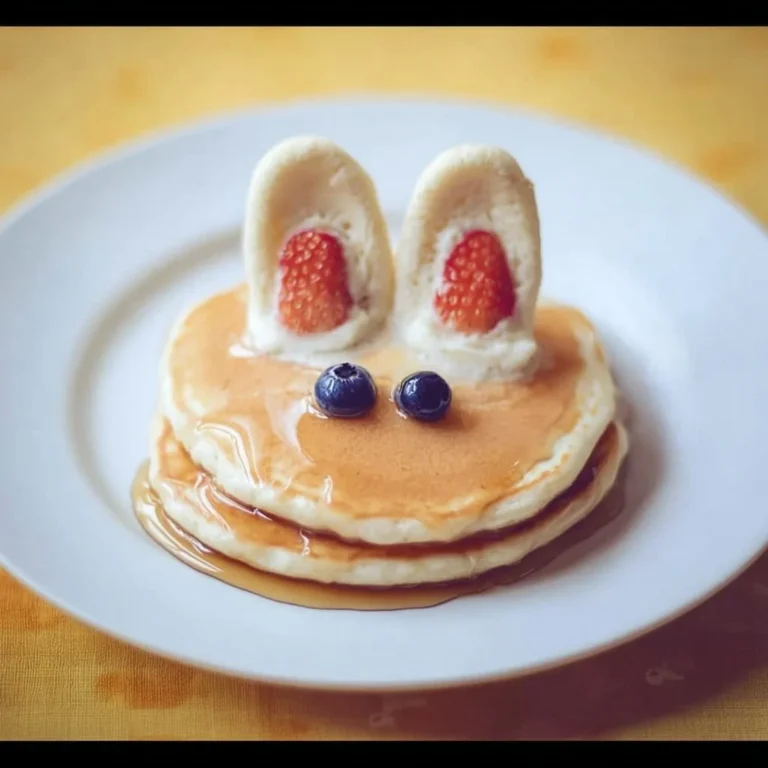 Plate of fluffy pancakes topped with syrup and berries