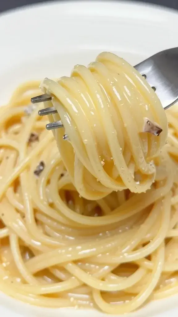 Closeup of creamy langostino pasta fork-twirled on a white plate