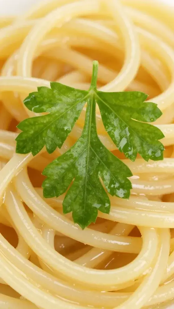 closeup of a single parsley leaf resting atop glossy linguine sauce