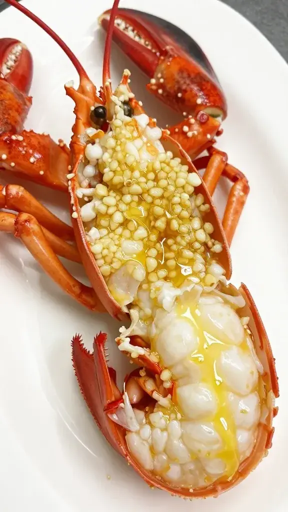 closeup of lobster claw meat with glistening garlic butter, on pristine plate, focus on texture