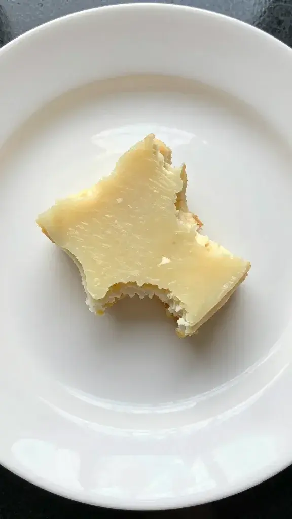 Single bite resting on white plate with subtle shine
