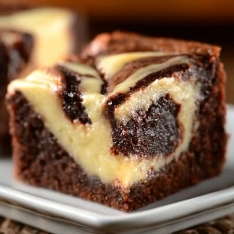 Cheesecake swirl fudge brownies topped with creamy cheesecake layer and chocolate drizzle