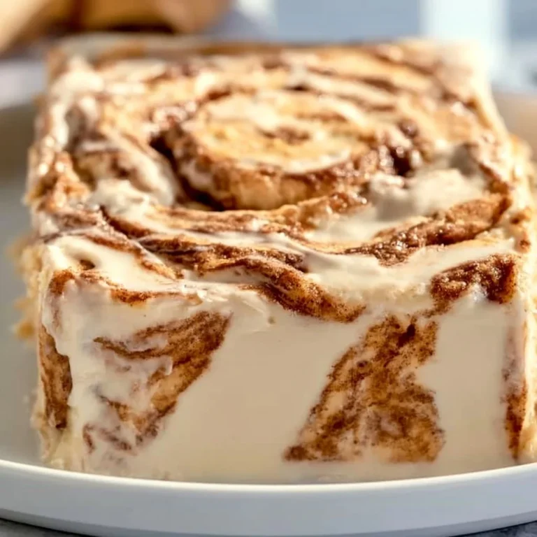 Delicious homemade cinnamon roll cake topped with icing on a plate.